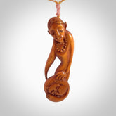 Hand carved stained bone female pendant in a repose shape with her cat. Made from natural bone. Bone jewellery from the Pacific for sale online. Female pendant for men and women.