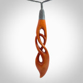 This necklace is carved from cow bone and stained with a homemade tea dye. It is a unique piece of wearable art that is sure to catch the eye. The shape is a complex twist form and has been beautifully hand carved by bone carver Yuri Terenyi.