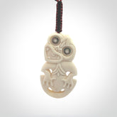 Hand carved bone Tiki pendant. Traditional art hand carved for NZ Pacific. Whalebone Tiki necklace with Paua Shell eyes. Free worldwide delivery. Provided to you on a hand plaited adjustable cord.