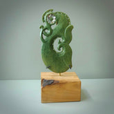 Hand carved New Zealand Jade Manaia sculpture with wooden stand. This is a large New Zealand Flower Jade Manaia sculpture hand carved here in New Zealand. This is a one only work of art and will be shipped to you with express courier.