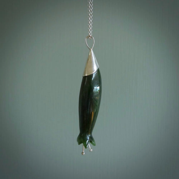 A photo of a harakeke, or flax flower, carved from a colourful piece of New Zealand flower jade. The cap and stamens are made from Sterling Silver and the cord is an Olive braid which is length adjustable.