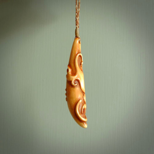 Bone carving of a lizard climbing. A three dimensional pendant carved in bone by Yuri Terenyi. One only contemporary gecko lizard carving for men and women. Provided with an adjustable cord.