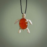 Fire Agate stone turtle in Sterling silver engraved casing. Hand carved jewellery made by NZ Pacific and for sale online. Moana, Ocean, jewellery hand carved in fire agate and Sterling Silver turtle necklace.