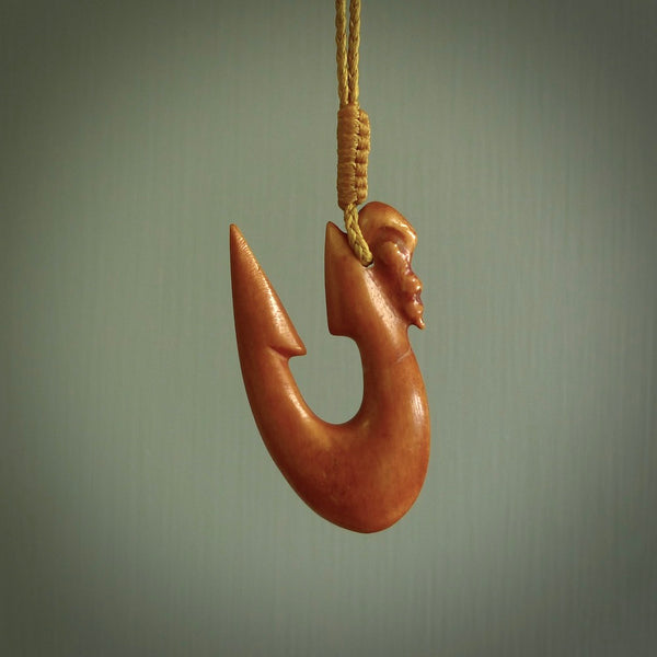 Natural stained cow bone manaia with hook pendant. Hand carved by Yuri Terenyi in New Zealand. Maori design pendant for sale online. One only stained bone manaia, hook necklace. Free delivery worldwide.