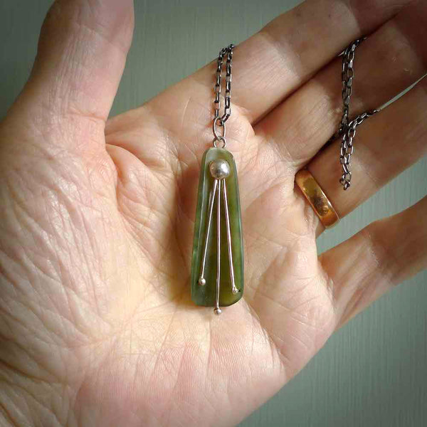 This kowhai flower drop pendant is beautifully hand made with gorgeous flair. It is fashionable and perfect for a women with style. Hand carved from a gorgeous piece of New Zealand jade with sterling silver - this is an elegant and beautiful piece of art to wear.