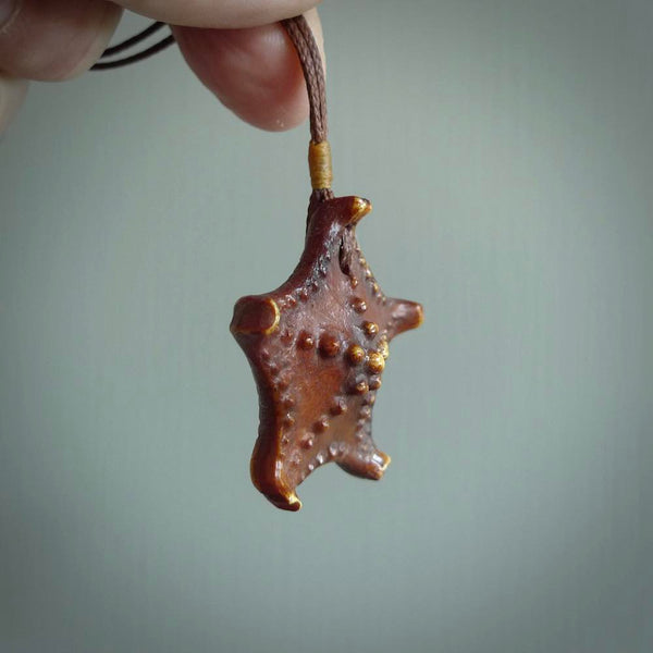 Hand carved bone starfish pendant. Ocean themed pendants carved by NZ Pacific. Moana pendants for sale online. Hand made stained bone sea star by Yuri Terenyi. We provide these starfish on adjustable brown or black cords. Postage is included in the price.