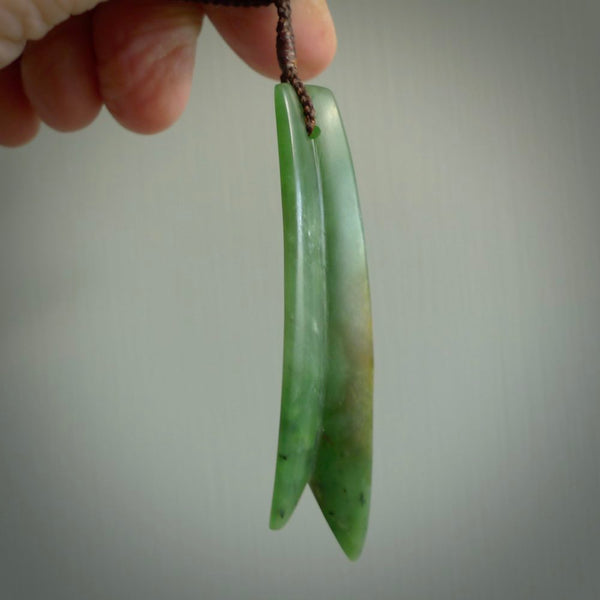This piece is a fine, delicate pendant. It was carved for us by Ric Moor from a lovely semi-translucent green piece of New Zealand Marsden jade. It is suspended on an dark brown  four plaited braided cord that is length adjustable.