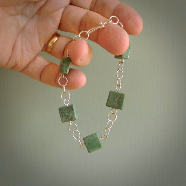 This bracelet is handmade from New Zealand Jade and sterling silver. It has five squared blocks of Jade in between a sterling silver chain, this is a fashionable bracelet for lovers of art to wear.