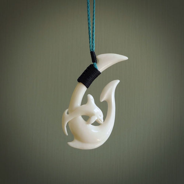 Hand carved bone hook with dolphin. This is a marine-themed pendant which we have made for dolphin lovers and for those of us that love the sea. This piece is handcarved from natural bone  and is shipped worldwide free.