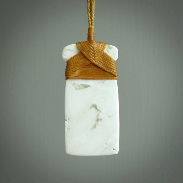 This pendant is a lovely toki carved from white onyx stone. It is a traditional shape and is traditionally bound but carved from a striking white stone. A beautiful piece of handmade jewellery from NZ Pacific.