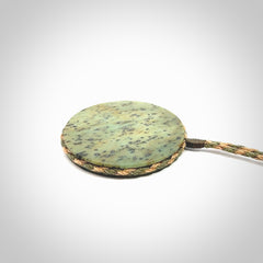 This piece is a contemporary disc pendant hand carved in New Zealand jade.