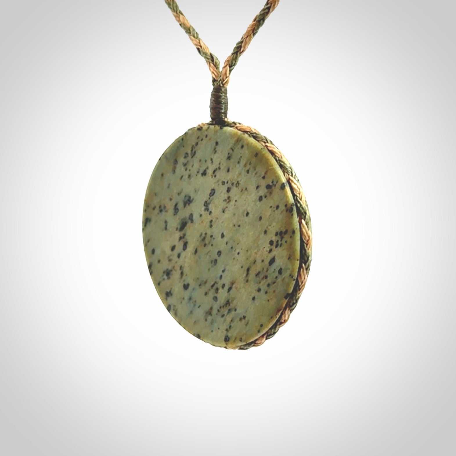 This piece is a contemporary disc pendant hand carved in New Zealand jade.