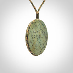 This piece is a contemporary disc pendant hand carved in New Zealand jade.