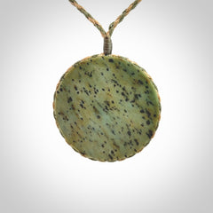 This piece is a contemporary disc pendant hand carved in New Zealand jade.