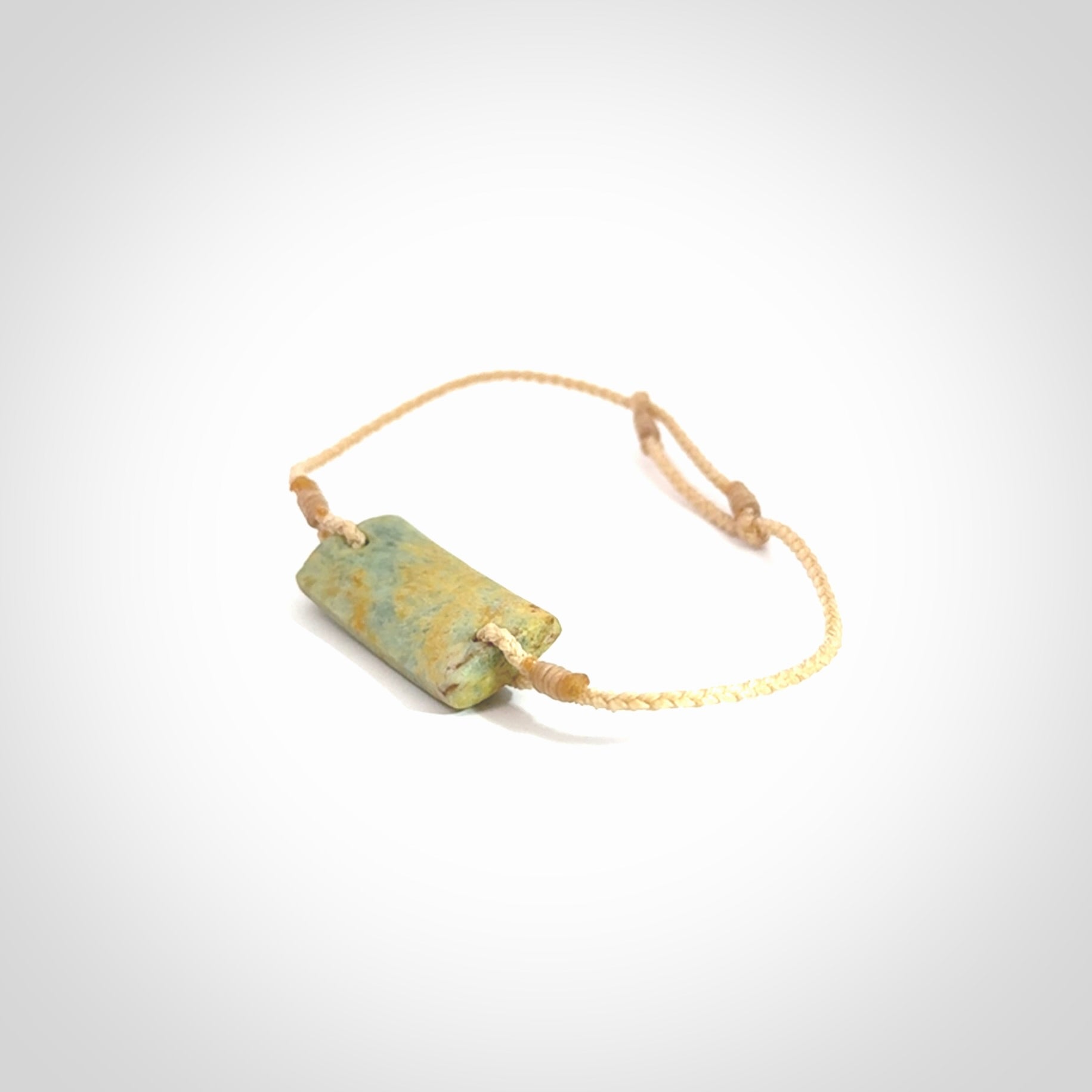 Hand carved New Zealand flower jade adjustable bracelet with beige cord. Carved in New Zealand jade by Ric Moor for NZ Pacific. One only armband for women and men.