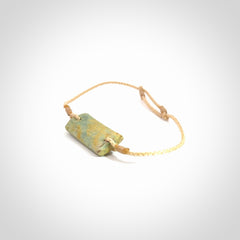 Hand carved New Zealand flower jade adjustable bracelet with beige cord. Carved in New Zealand jade by Ric Moor for NZ Pacific. One only armband for women and men.