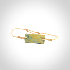 Hand carved New Zealand flower jade adjustable bracelet with beige cord. Carved in New Zealand jade by Ric Moor for NZ Pacific. One only armband for women and men.
