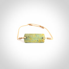 Hand carved New Zealand flower jade adjustable bracelet with beige cord. Carved in New Zealand jade by Ric Moor for NZ Pacific. One only armband for women and men.