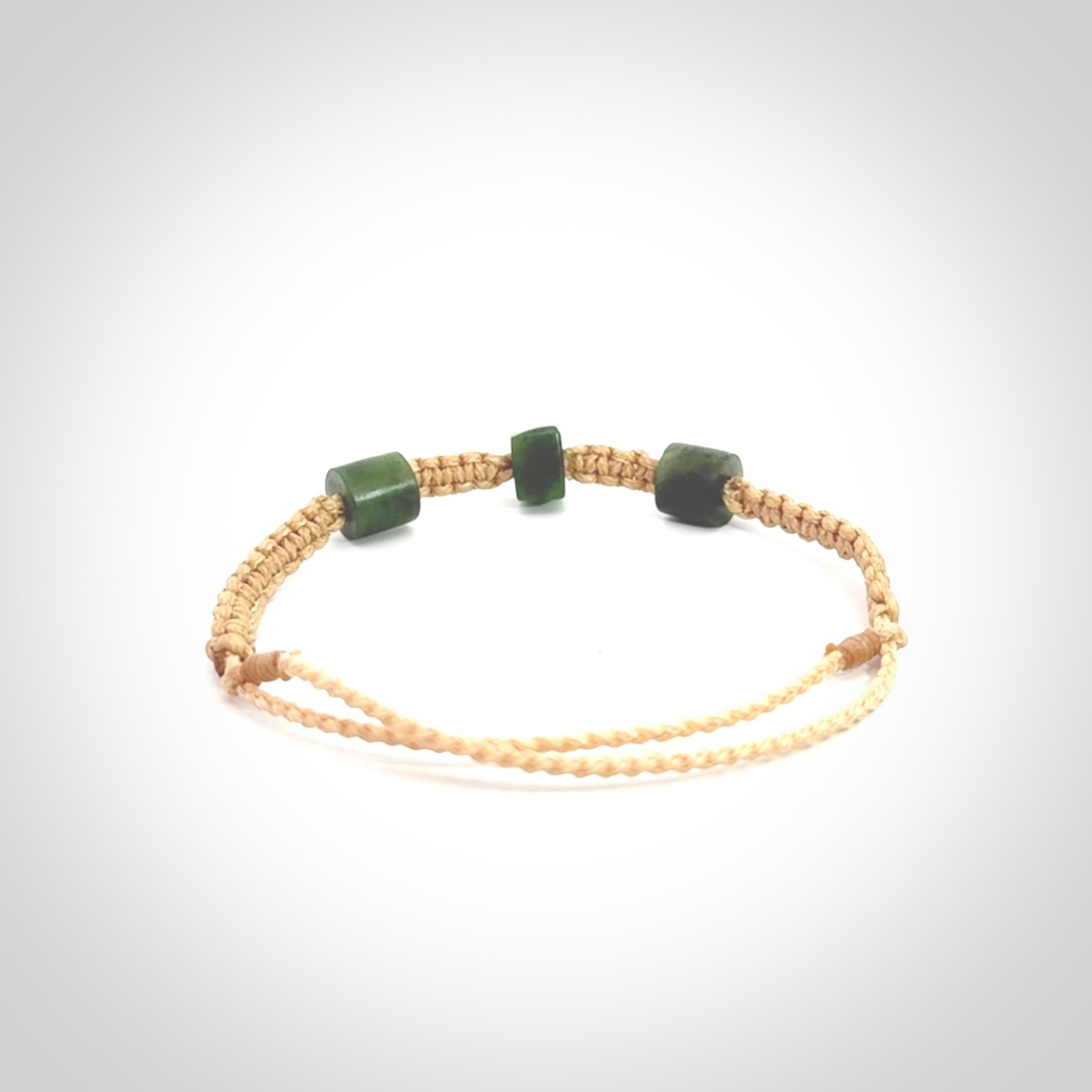 Hand carved New Zealand jade adjustable bracelet with beige cord. Carved in New Zealand jade by Ric Moor for NZ Pacific. One only armband for women and men.