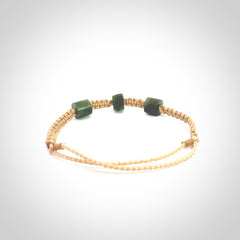 Hand carved New Zealand jade adjustable bracelet with beige cord. Carved in New Zealand jade by Ric Moor for NZ Pacific. One only armband for women and men.