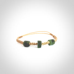 Hand carved New Zealand jade adjustable bracelet with beige cord. Carved in New Zealand jade by Ric Moor for NZ Pacific. One only armband for women and men.