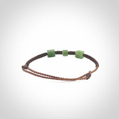 Hand carved New Zealand jade adjustable bracelet with brown cord. Carved in New Zealand jade by Ric Moor for NZ Pacific. One only armband for women and men.