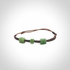 Hand carved New Zealand jade adjustable bracelet with brown cord. Carved in New Zealand jade by Ric Moor for NZ Pacific. One only armband for women and men.