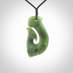 This picture shows a jade hook pendant, also called a hei-matau, carved for us in New Zealand jade. The cord is a four-plait, adjustable black coloured necklace.
