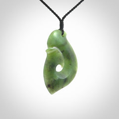 This picture shows a jade hook pendant, also called a hei-matau, carved for us in New Zealand jade. The cord is a four-plait, adjustable black coloured necklace.