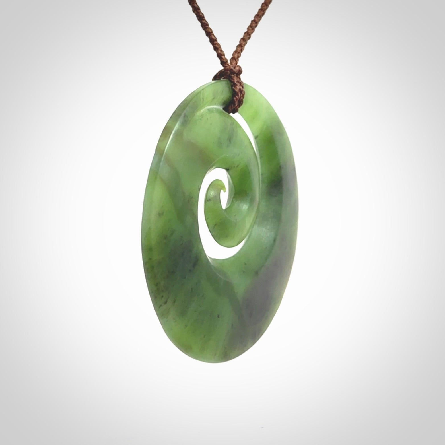 This picture shows a hand carved New Zealand jade koru pendant