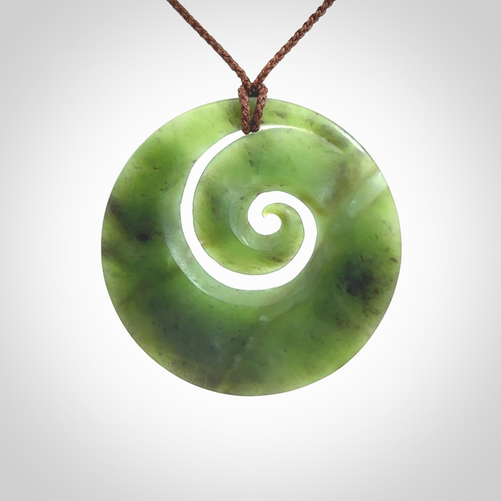 This picture shows a hand carved New Zealand jade koru pendant