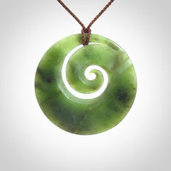 This picture shows a hand carved New Zealand jade koru pendant