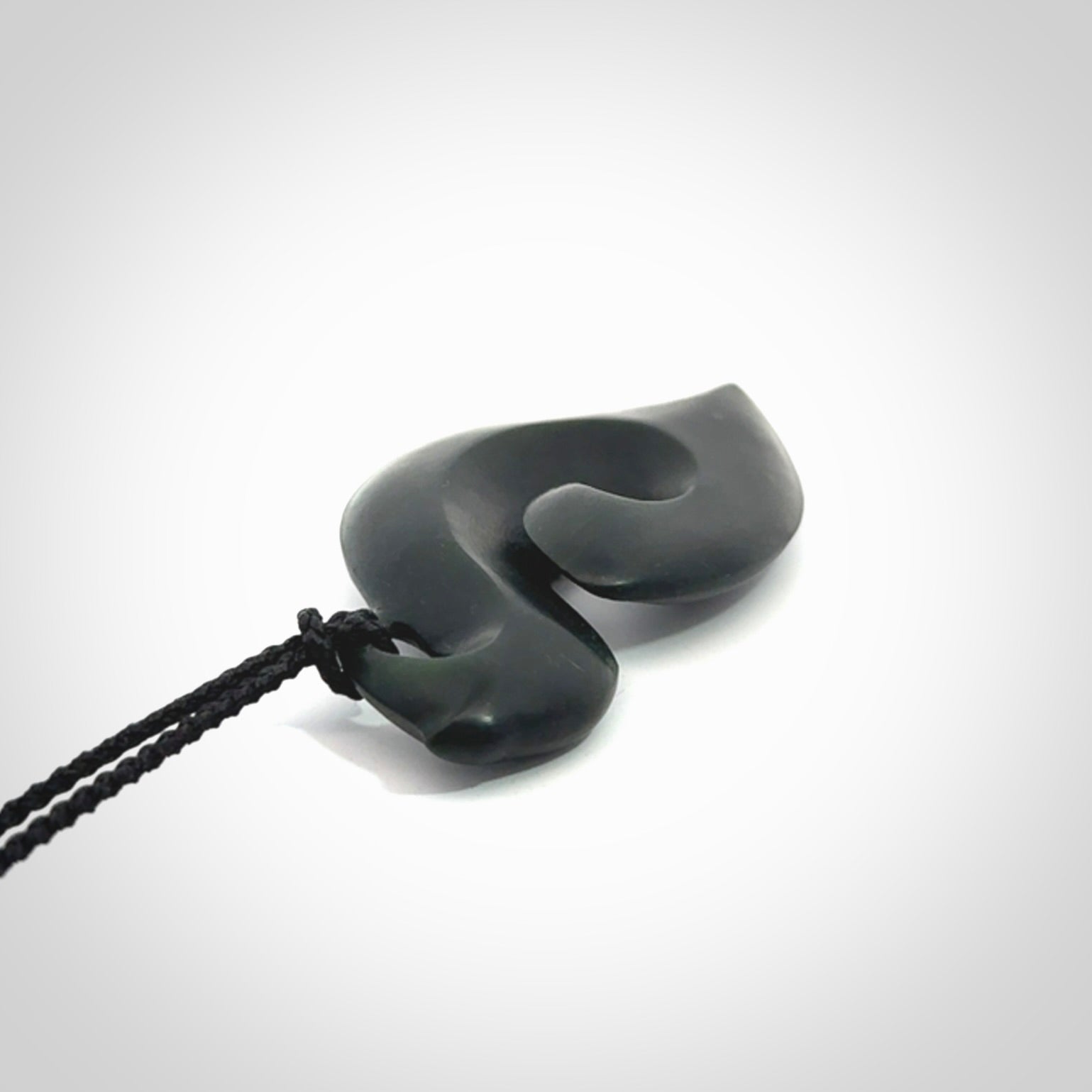 A hand carved New Zealand Jade contemporary koru pendant.