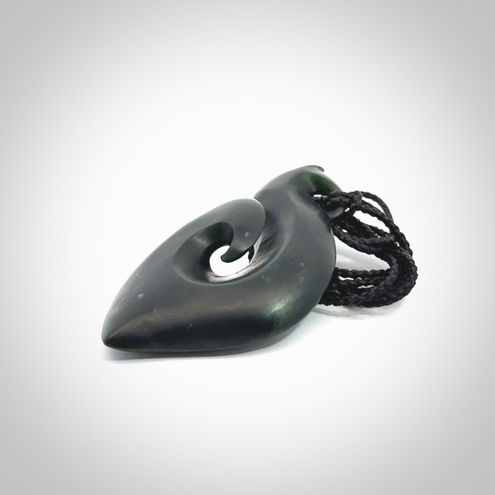 A hand carved New Zealand Jade contemporary koru pendant.