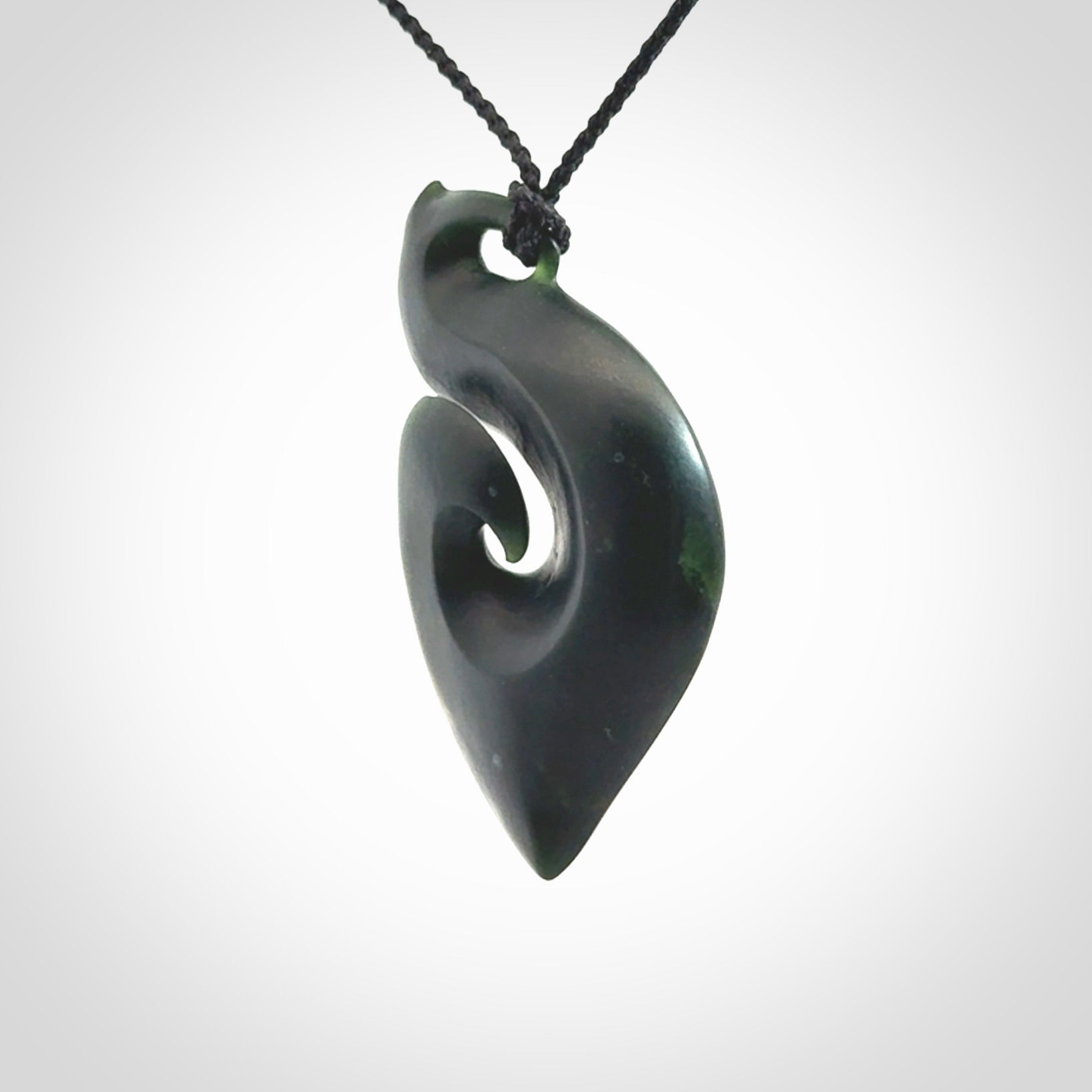 A hand carved New Zealand Jade contemporary koru pendant.