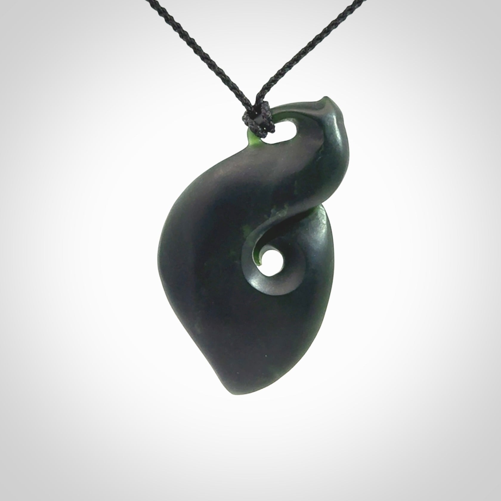 A hand carved New Zealand Jade contemporary koru pendant.