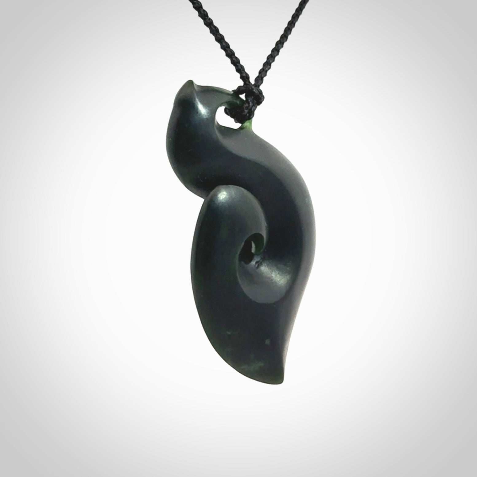 A hand carved New Zealand Jade contemporary koru pendant.