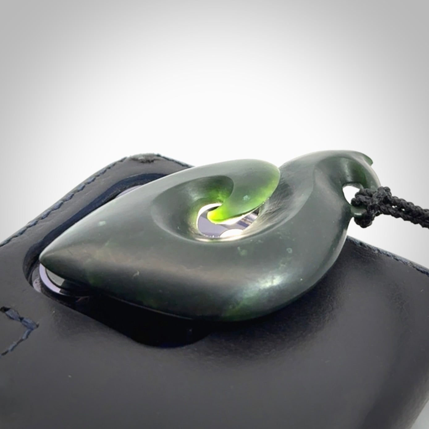 A hand carved New Zealand Jade contemporary koru pendant.