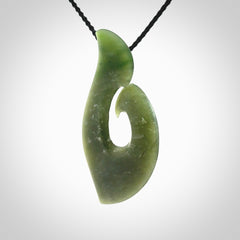 This picture shows a hand carved jade koru pendant. It is a deep green colour and is a wonderful, piece of jewellery. The cord is a four plait black colour and adjustable so that you can position the pendant where it suits you best. Delivery is free worldwide.