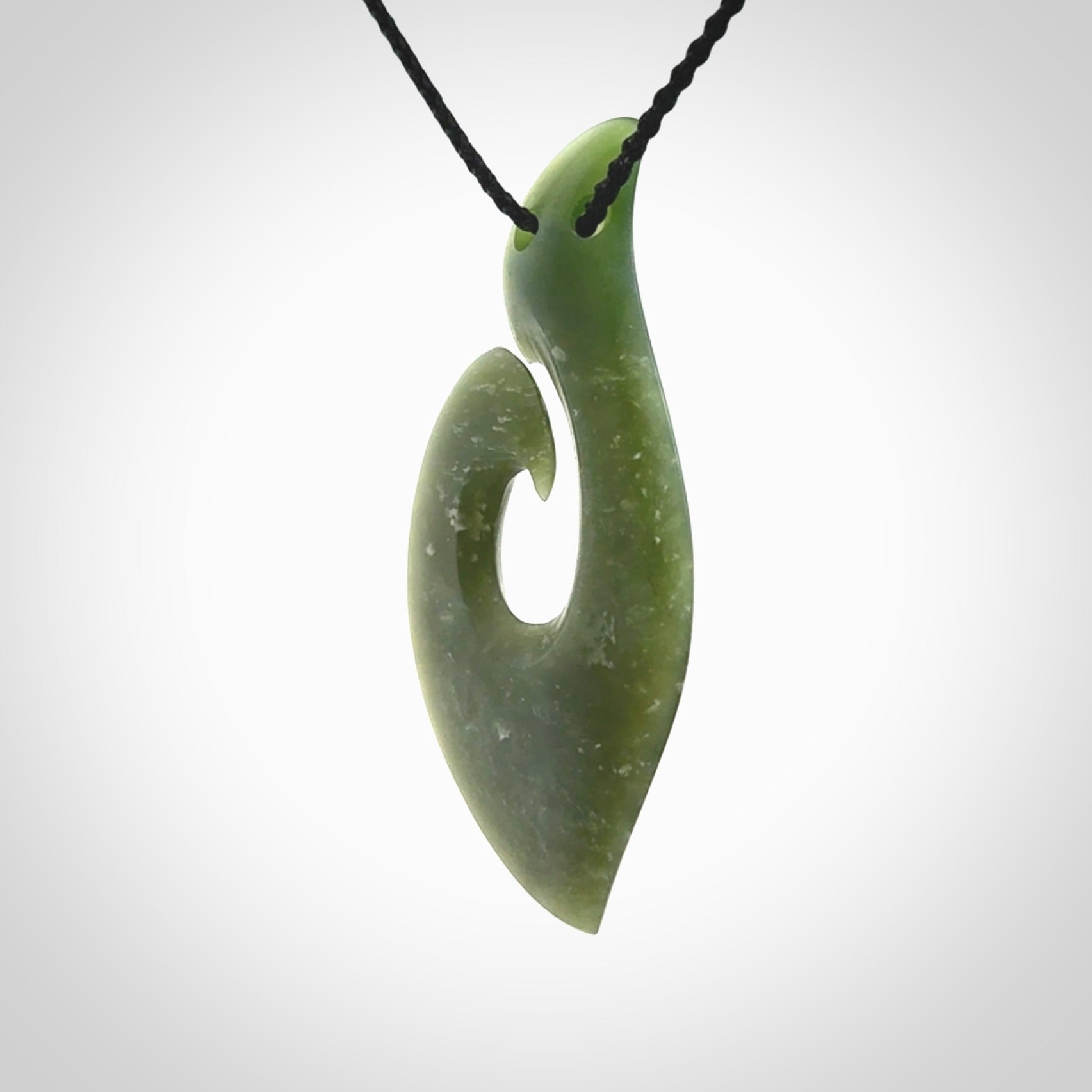 This picture shows a hand carved jade koru pendant. It is a deep green colour and is a wonderful, piece of jewellery. The cord is a four plait black colour and adjustable so that you can position the pendant where it suits you best. Delivery is free worldwide.