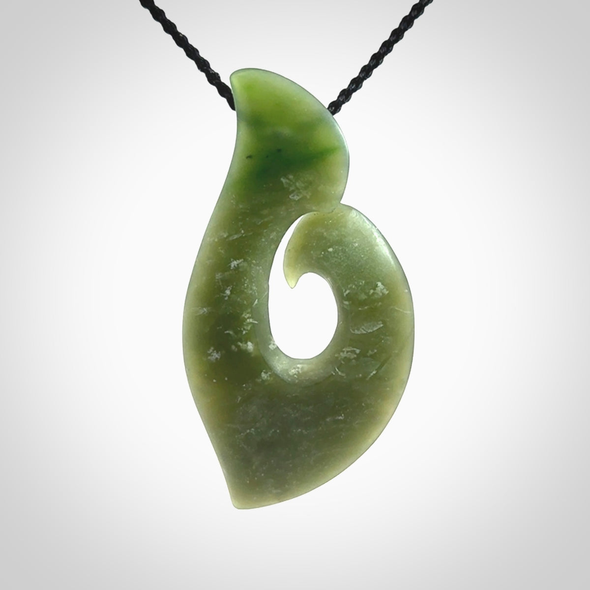 This picture shows a hand carved jade koru pendant. It is a deep green colour and is a wonderful, piece of jewellery. The cord is a four plait black colour and adjustable so that you can position the pendant where it suits you best. Delivery is free worldwide.
