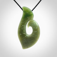 This picture shows a hand carved jade koru pendant. It is a deep green colour and is a wonderful, piece of jewellery. The cord is a four plait black colour and adjustable so that you can position the pendant where it suits you best. Delivery is free worldwide.