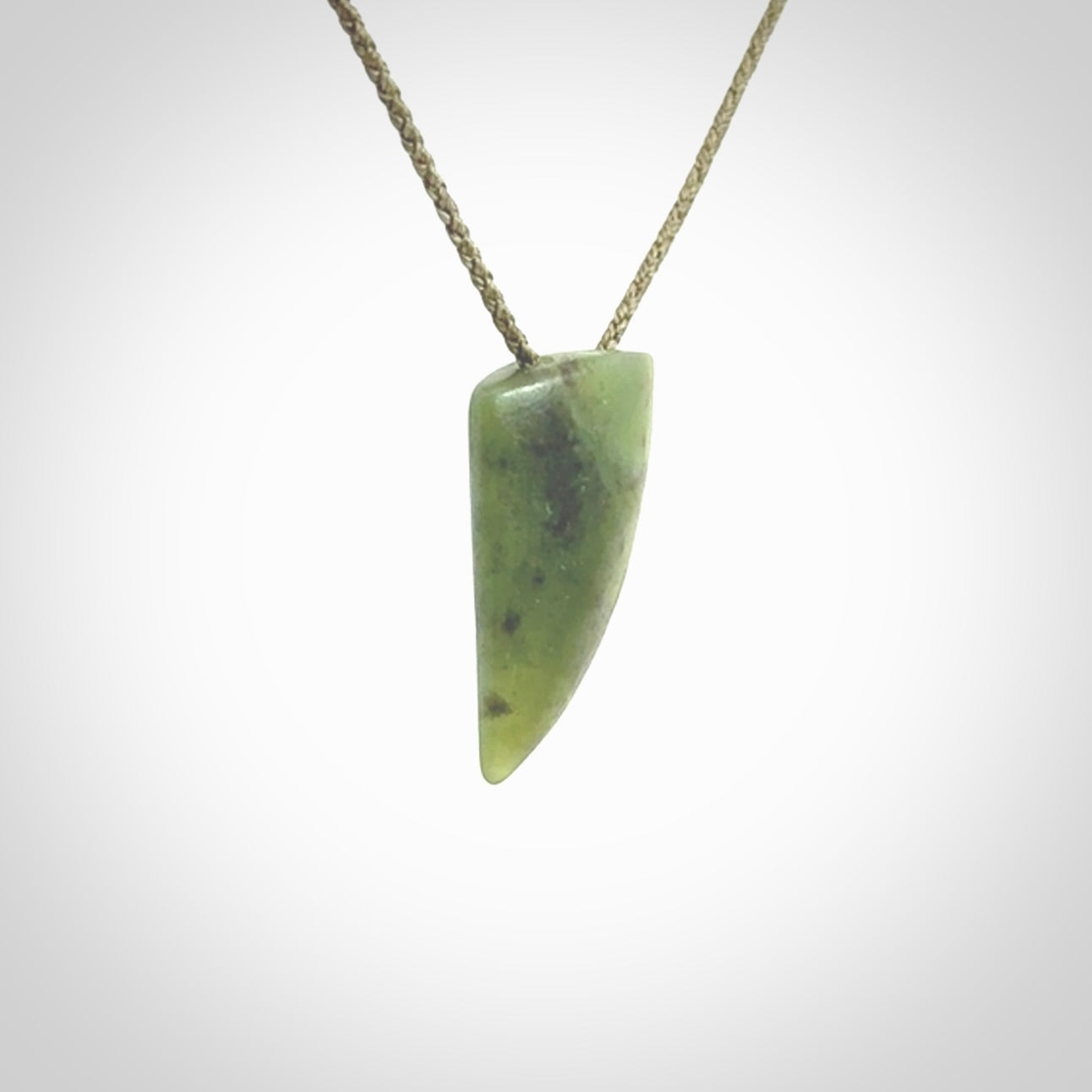 This is a lovely New Zealand Jade, pounamu niho drop pendant. It is bound with an adjustable khaki coloured cord which is length adjustable.