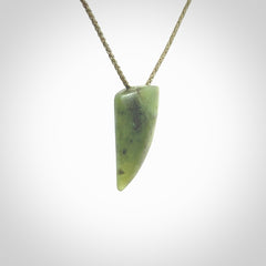 This is a lovely New Zealand Jade, pounamu niho drop pendant. It is bound with an adjustable khaki coloured cord which is length adjustable.