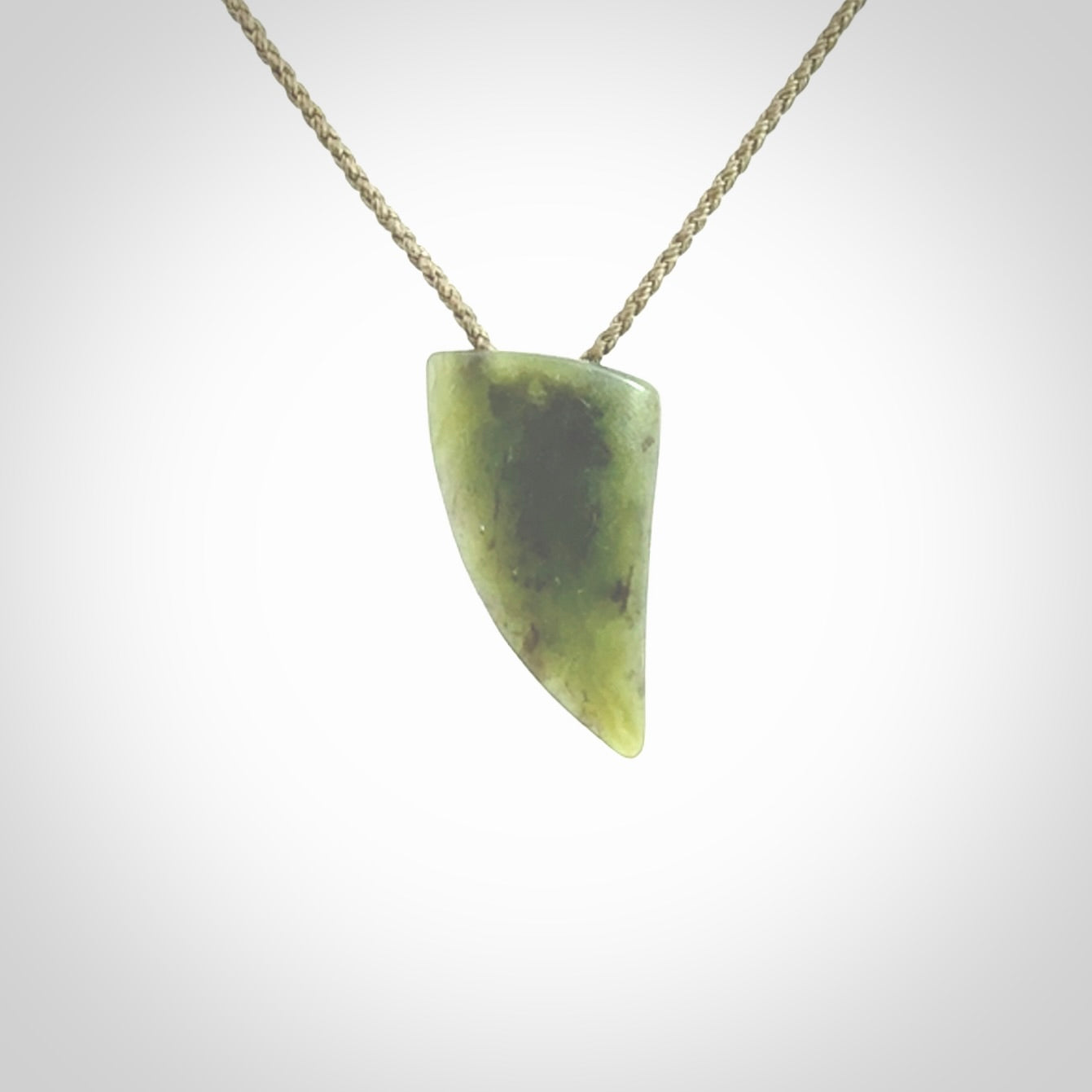 This is a lovely New Zealand Jade, pounamu niho drop pendant. It is bound with an adjustable khaki coloured cord which is length adjustable.