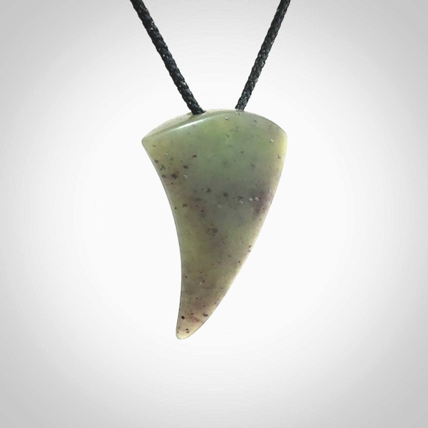 This is a lovely New Zealand Jade, pounamu niho drop pendant. It is bound with an adjustable black coloured cord which is length adjustable.