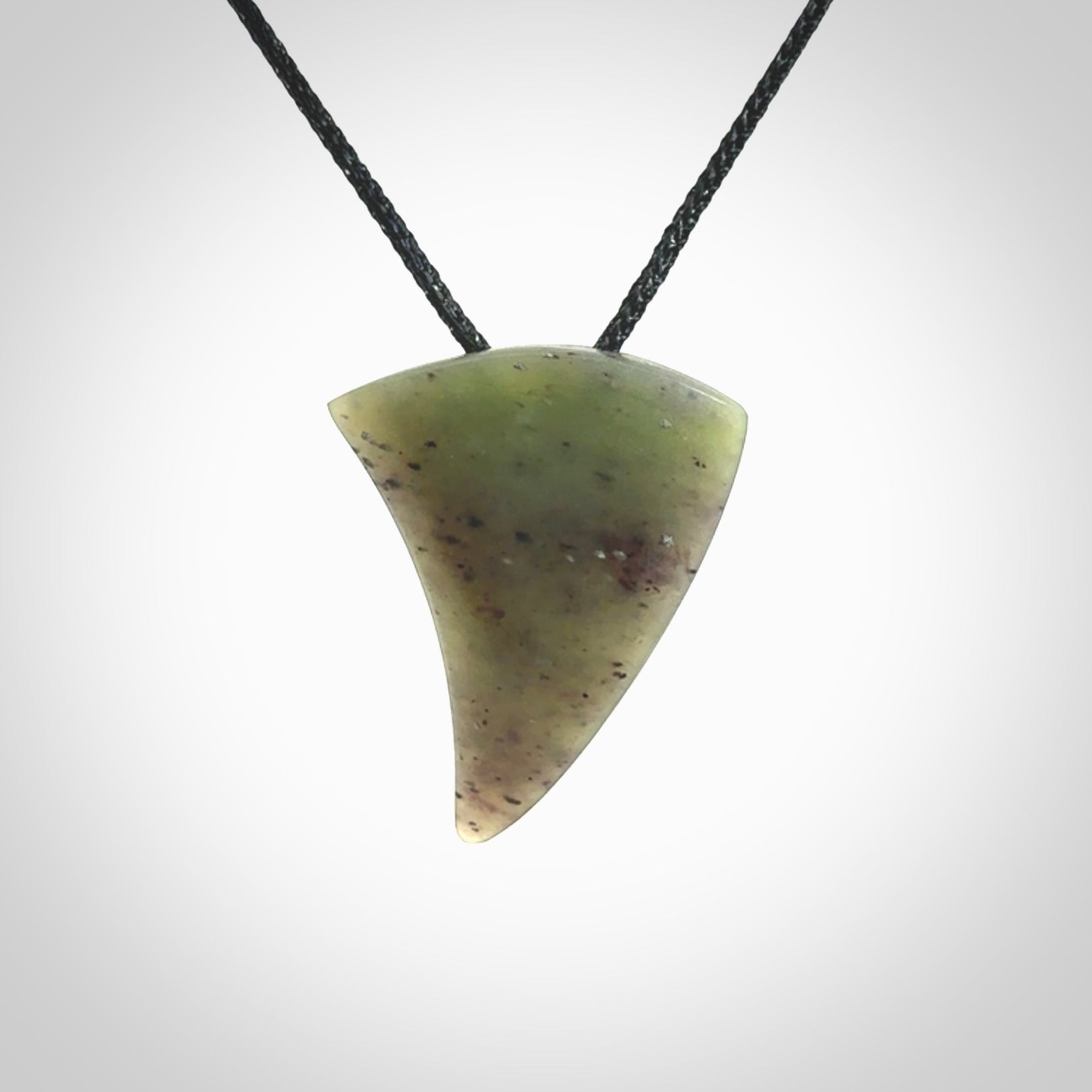 This is a lovely New Zealand Jade, pounamu niho drop pendant. It is bound with an adjustable black coloured cord which is length adjustable.