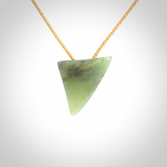 This is a lovely New Zealand Jade, pounamu niho drop pendant. It is bound with an adjustable beige coloured cord which is length adjustable.