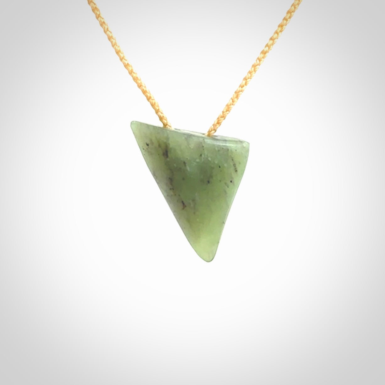 This is a lovely New Zealand Jade, pounamu niho drop pendant. It is bound with an adjustable beige coloured cord which is length adjustable.