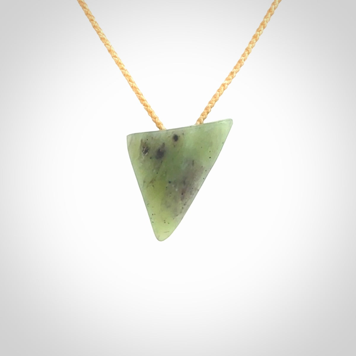 This is a lovely New Zealand Jade, pounamu niho drop pendant. It is bound with an adjustable beige coloured cord which is length adjustable.